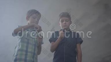 两个小男孩在一个烟雾弥漫的废弃房间里。 一个男孩拿着燃烧的火柴，第二个男孩拿着燃烧的<strong>打火</strong>机