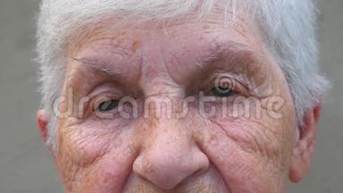 闭上祖母灰色的眼睛，眼睛周围有皱纹。一位老太太用