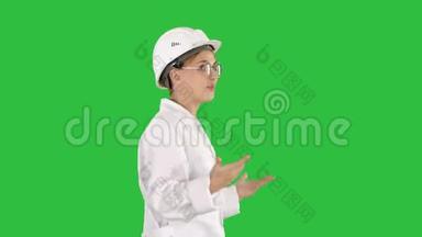 年轻的科学家，穿着实验室外套，戴着安全帽，在绿色屏幕<strong>上走来走去</strong>，说些什么，Chroma键。
