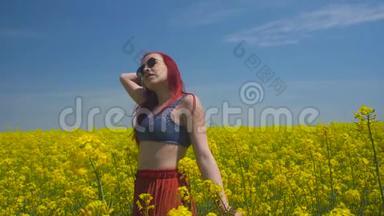 年轻女子在科尔扎中心绽放的黄色田野随风起舞