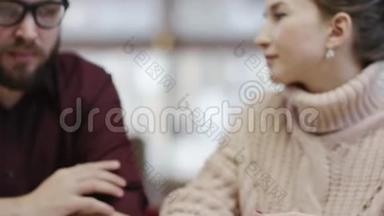 一名成年男子和女友坐在餐厅用智能手机支付账单