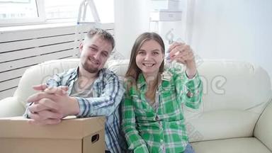 购租房地产的概念.. 幸福的年轻夫妇带着新家的钥匙