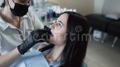 牙医用牙科工具检查病人牙齿，动作缓慢。 牙医办公室的女人。