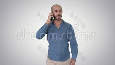 年轻的阿拉伯男人在电话里<strong>走来走</strong>去，在渐变的背景下微笑。