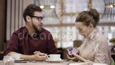 年轻的女人看着里面的心形盒子，她在餐馆里得到了她丈夫的前额