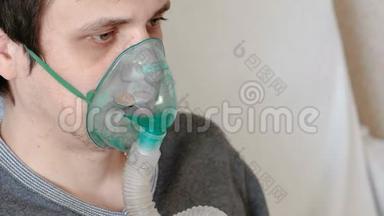 使用<strong>雾化器</strong>和吸入<strong>器</strong>进行治疗。 特写男人`他的脸通过吸入面罩吸入。 前景。