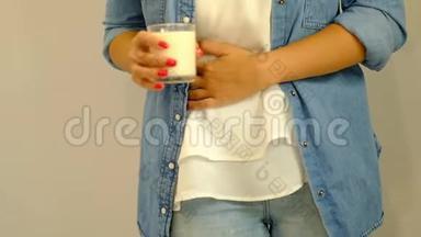 慢动作。 医疗保健和医疗观念女人手拿着一杯牛奶，因为胃痛