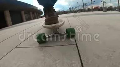 特写滑板少年骑户外.. 一个年轻人在公园里玩长木板。 穿着旅行靴。 城市
