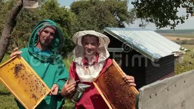 两个穿绿色和红色特别服装的<strong>养蜂</strong>人收集蜂蜜