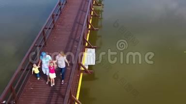家庭在桥上一起散步的鸟瞰图。 爸爸妈妈带着儿子和女儿