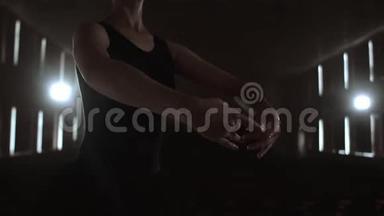 中间计划慢动作：一个年轻的芭蕾舞女演员在舞台上表演优美的动作，穿着芭蕾<strong>舞鞋</strong>和尖鞋
