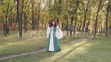 漂亮可爱的女士，一头红色的卷发，一身绿色宽松的民族服装的丰满的大模特，手里拿着苹果