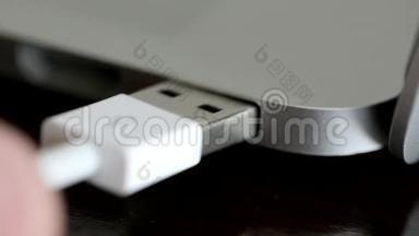 USB白色电缆连接到笔记本电脑。 宏观镜头
