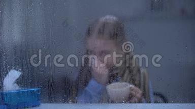 生病的女孩打喷嚏，在<strong>雨</strong>窗后喝热茶，流感病毒<strong>流行</strong>