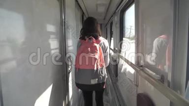 十几岁的女孩带着背包在火车车厢里散步。 旅游运输铁路概念。 小女孩走路