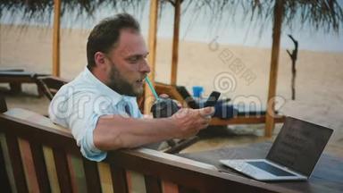 成功的轻松商人使用智能<strong>手机</strong>娱乐，同时在夏<strong>季</strong>海洋度假海滩在线工作。