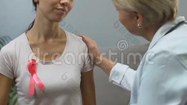 年轻女子带粉色丝带拥抱医生，检测结果良好，无乳腺癌