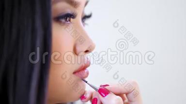 专业化妆师将裸唇光泽应用于亚洲模特Choker拍摄侧视