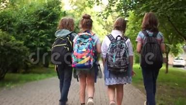 同学们在大街上上学。第一个上学日，回到学校。儿童背包，后视图