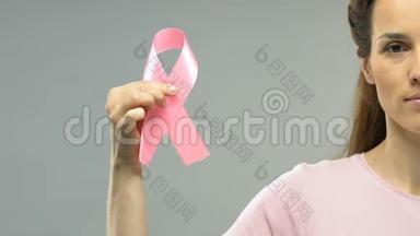 女子手持粉红丝带，有乳腺癌意识，需<strong>定期</strong>检查