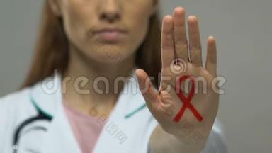 医生手上涂有红丝带，防治艾滋病