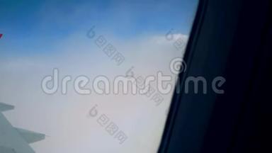 透过飞机窗户观看蓝天和云彩，带有飞机机翼的飞机窗户，特写