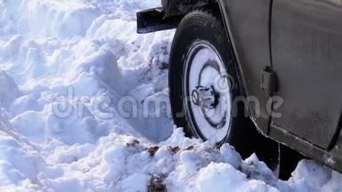 一辆被困在雪地里的汽车使车轮转动