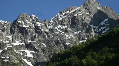 用高加索高岩山脉的双手拍摄的特写视频全景，还有雪的残骸