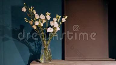 玻璃花瓶与轻轻的<strong>粉</strong>红色康乃馨站在一张木桌上的背景墙。 内部的一部分