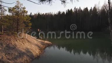 年轻女子在拉脱维亚波罗的海国家的一个绿松石色湖上用手机拍照