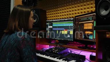 女音乐家歌曲作者在录音室弹钢琴MIDI键盘。 女声工程师在家庭音乐工作室工作