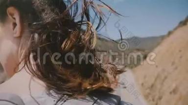 近距离后景拍摄的年轻旅游妇女与头发在<strong>大风</strong>中飞行，享受在比克斯比桥，大苏尔。