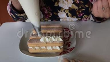 一个女人在萨沃亚迪<strong>饼</strong>干上涂上奶油。 用糕点包。 以<strong>鲜花</strong>的形式