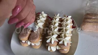 一个女人在萨沃亚迪饼干上涂上奶油。 用糕点包。 以鲜花的形式