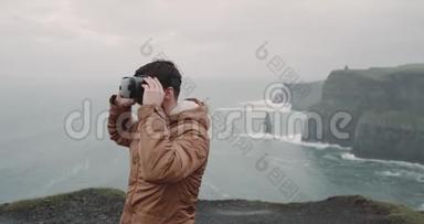 特写男用VR眼镜环游世界，他站在莫赫悬崖上，用VR兴高采烈。