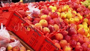在超市橱窗上贴有价格标签的苹果和路过的购物者。