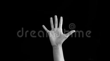 单个人手向上移动他的手腕顺时针和逆时针做手腕放松运动孤立在黑色。