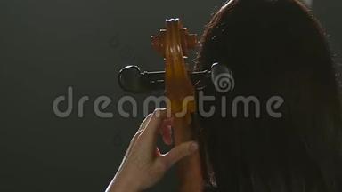 音乐家回到镜头播放大提琴。 黑烟背景