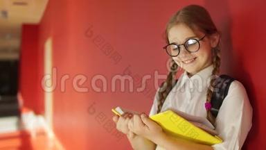 扎着辫子的女孩在学校走廊读教科书。 回到学校，准备考试，学校放假