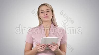 中镜头的美女使用平板电脑翻页，并在的渐变背景。