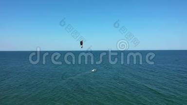 鸟瞰人风筝冲浪在绿松石海。 无人机视野飞行的风筝冲浪者。 风筝冲浪者冲浪晶莹剔透的水。 黑色S