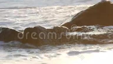 海上黎明。美丽的大风暴波，泡沫覆盖着海岸上的巨石巨石，极端的波浪破碎