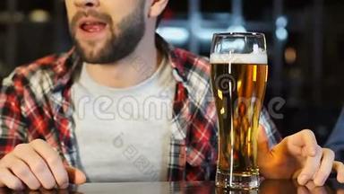 男迷坐在酒吧里看<strong>体育比赛</strong>，喝新鲜啤酒