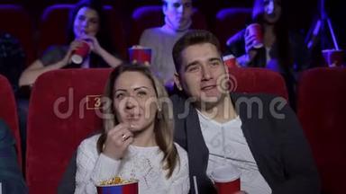 夫妻俩坐在一起看电影，看浪漫电影，吃爆米花。
