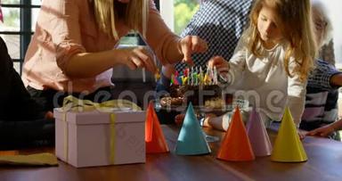 母亲和女儿在客厅4k的生日蛋糕上装饰蜡烛