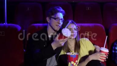 夫妻俩坐在一起看电影，看浪漫电影，吃爆米花。