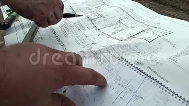一名建筑师和一名建筑工程师检查建筑平面图，比较建筑的精确尺寸