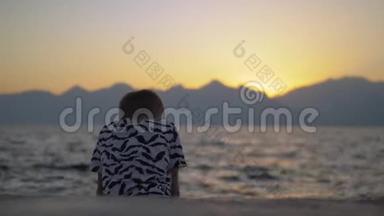 日落时海滩上孤独的孩子