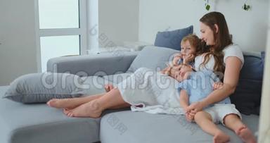 妈妈穿着裙子，小孩子坐在沙发上看<strong>你最</strong>喜欢的电视剧