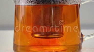 将茶袋中的红茶叶用开水冲泡浸泡到玻璃透明茶壶锅中，延时拍摄，关闭